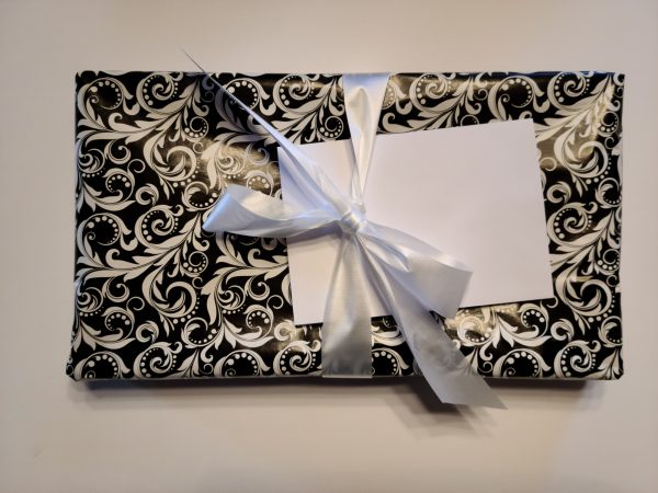 Sample of gift wrapped packaged tied with white ribbon and envelope